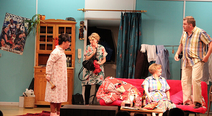 Dreifach weiblicher Besuch (v. l. Gabi Gützkow alias Luise, Julia Holzwarth alias Moni und Christiane Raidt alias Birgit) stiftete reichlich Verwirrung bei Junggeselle Sven (Ralf Haller). Bild: Benedikt Buggle